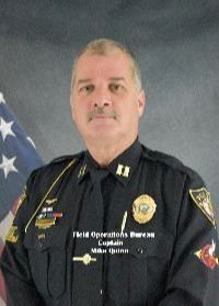 Headshot of Mike Quinn in front of an American Flag