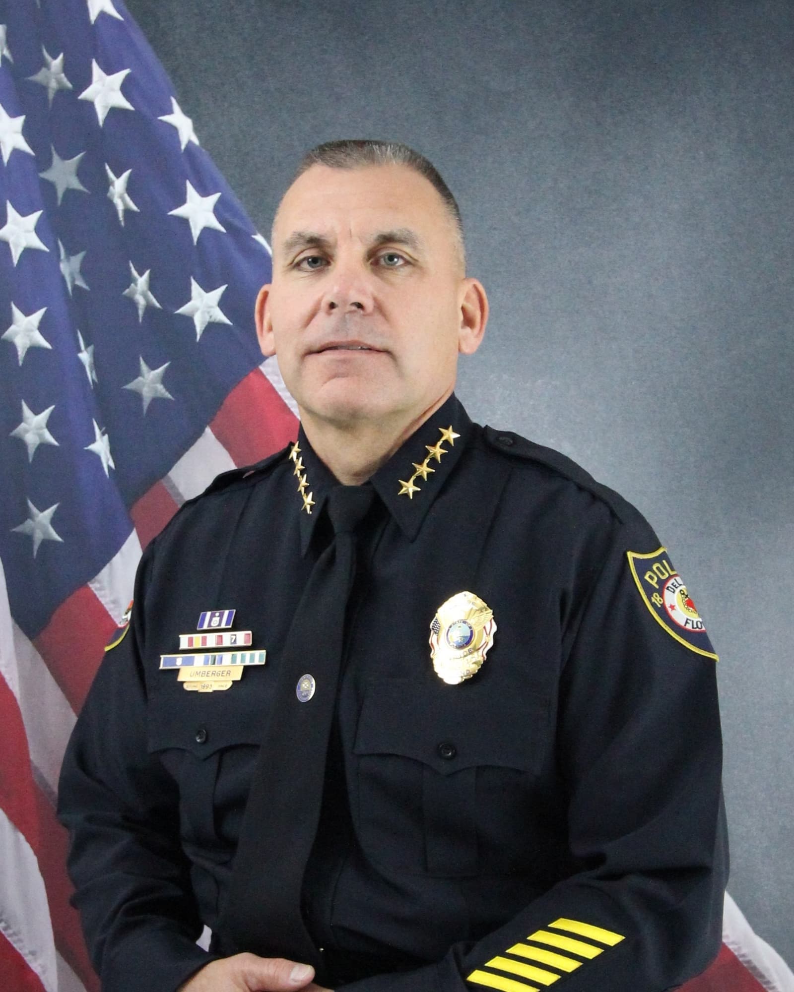Jason Umberger sits in front of an American Flag in the background.